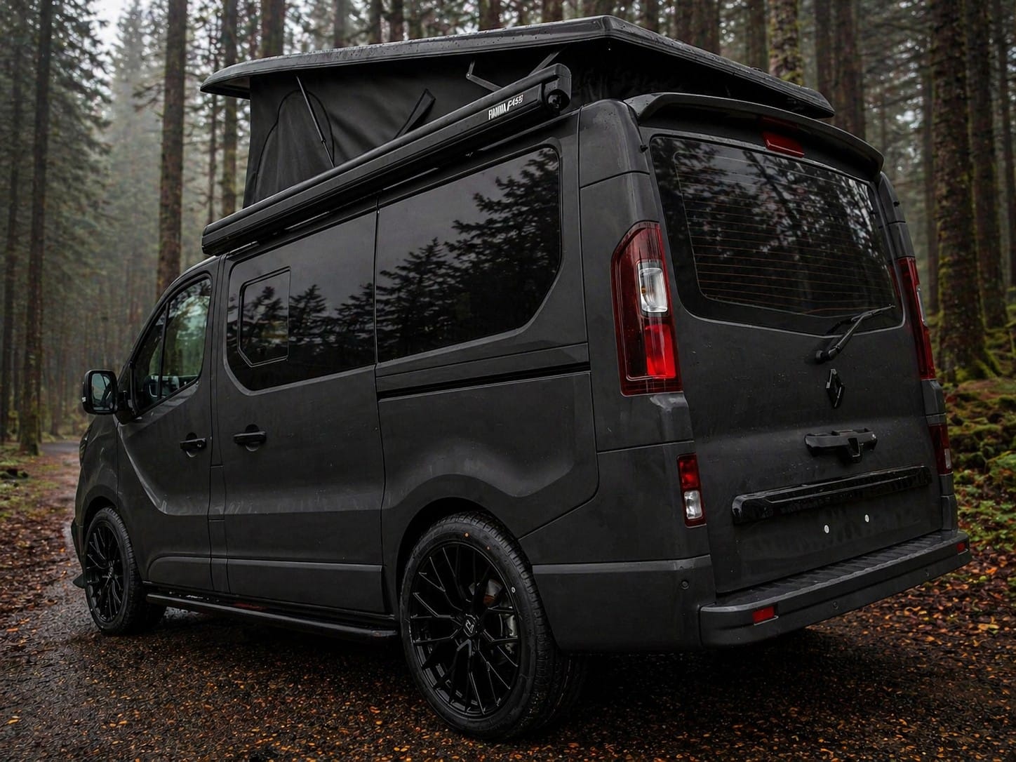 Rear three quarter view of a matt black Escape Crusader Renault Trafic campervan with the pop top raised