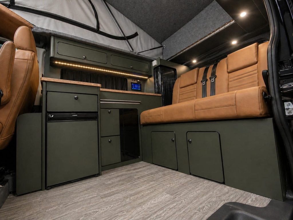Tan leather rear seat bed and kitchen units inside an Escape Crusader Renault Trafic campervan