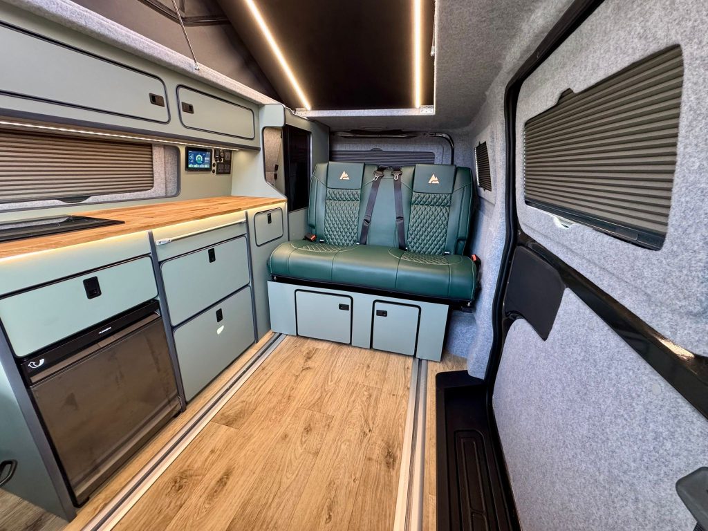 Interior of an Escape Breeze Plus campervan looking towards the two seat rear bench that folds into a double bed