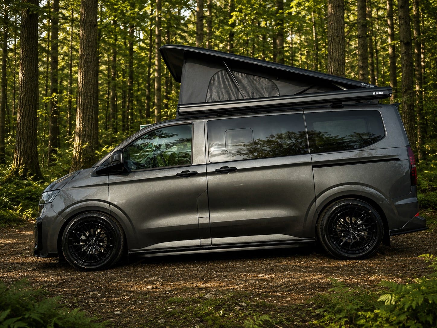 Side view of a short wheelbase VW T7 Escape Breeze Plus campervan with the pop top raised in woodland