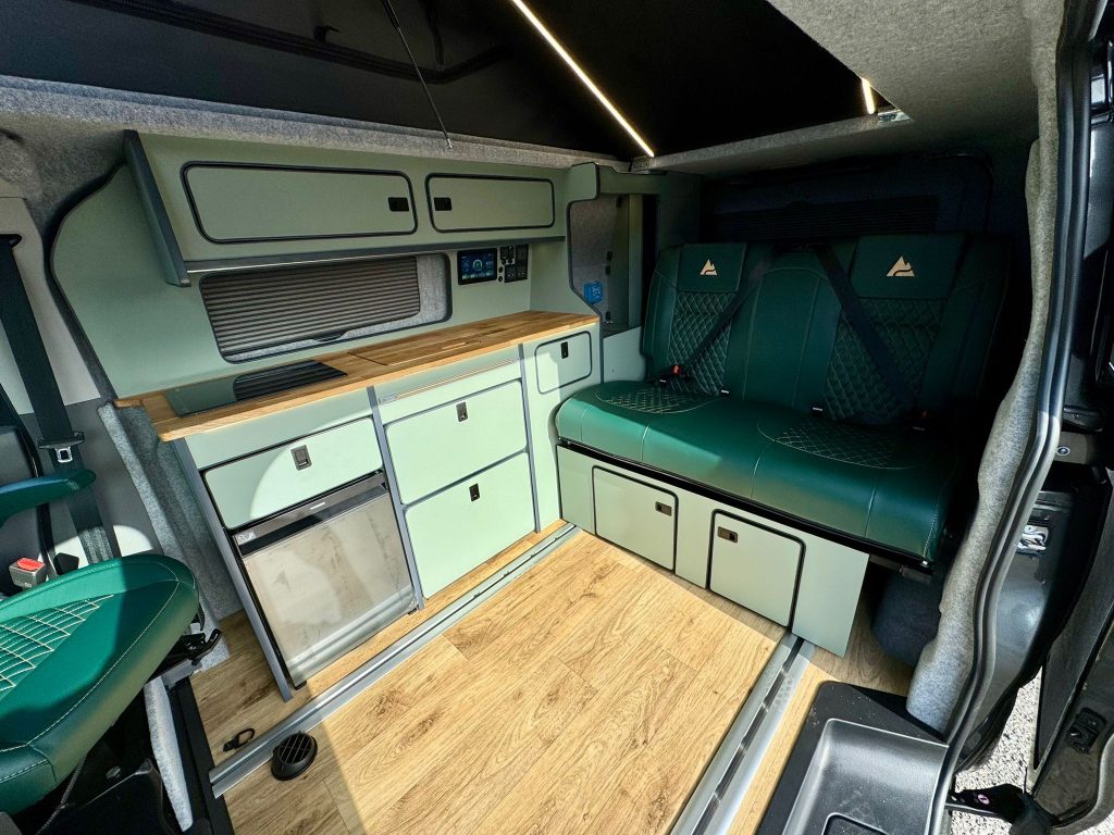 Kitchen units, oak worktop and rear seat bed inside a short wheelbase Escape Breeze Plus campervan